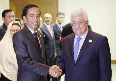 Indonesian President Joko Widodo, left, greets Palestinian President Mahmoud Abbas at the start of their bilateral meeting on the sidelines of the extraordinary Organization of Islamic Cooperation (OIC) summit on Palestinian issues in Jakarta, Indonesia o