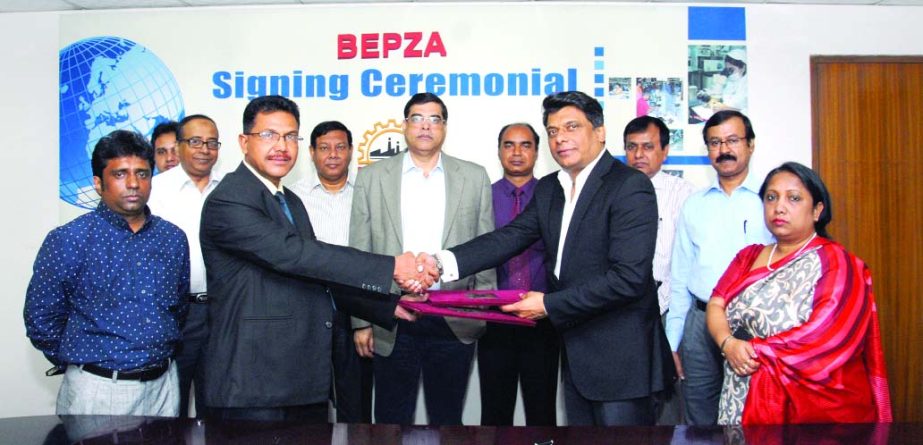 Abdul Halim Molla, Member of BEPZA exchanging documents with Mohd Siddiqui, Director of Hoi Bun Fashions Ltd. at BEPZA Complex in the city on Monday.