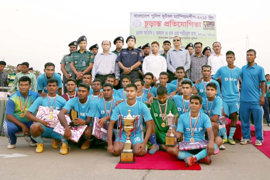 Members of Dhaka Metropolitan Police (DMP), the champions of the Bangladesh Police Football Tournament with the guests and officials of Bangladesh Police pose for a photo session at the Rajarbagh Police Lines Ground on Tuesday. DMP beat Khulna Range team