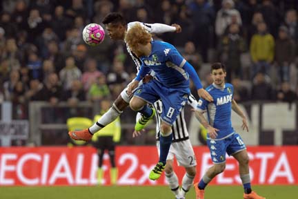 Juventus' Alex Sandro (left) jumps for the ball with Sassuolo's Matteo Biondini during a Serie A soccer match between Juventus and Sassuolo at the Juventus stadium in Turin, Italy on Friday.