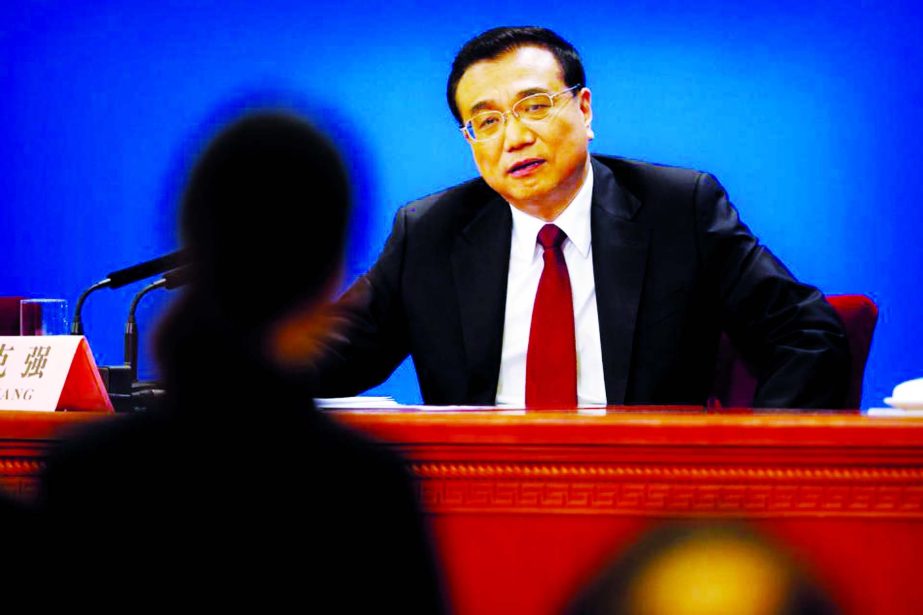 Chinese Premier Li Keqiang listens to a question from a reporter, in foreground, during a press conference after the closing session of the annual National People's Congress held in Beijing's Great Hall of the People on Wednesday.