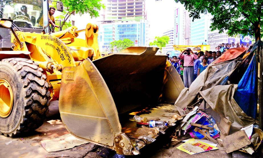 As part of the continuous efforts to clean city, DSCC evicting illegal structures built at the Kazi Nazrul Islam Avenue area near Sonargaon Hotel on Wednesday.