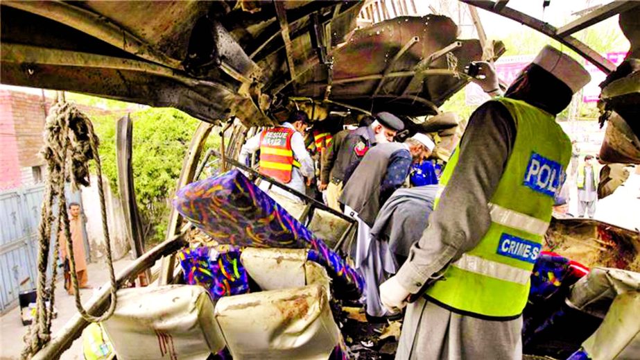 Pakistani security staff examine the bus following a blast in Peshawar on Wednesday.