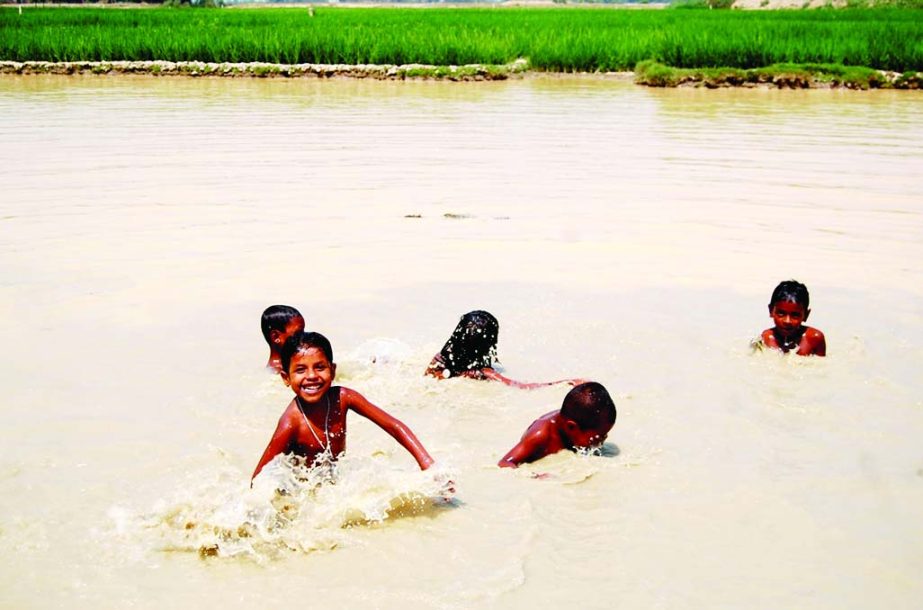 SYLHET: Children rejoicing with water in a canal due to excessive heat wave at village Baishtila in Sylhet. This picture was taken on Wednesday.