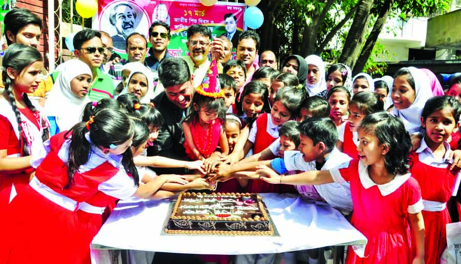 Assistant Secretary of Awami League Central Sub-Committee Hashibur Rahman Manik along with the students of different schools cutting cake marking 97th birthday of Father of the Nation Bangabandhu Sheikh Mujibur Rahman and National Children Day in the city