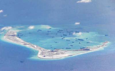 An aerial photo taken though a glass window of a Philippine military plane shows the alleged on-going land reclamation by China on mischief reef in the Spratly Islands in the South China Sea, west of Palawan, Philippines.