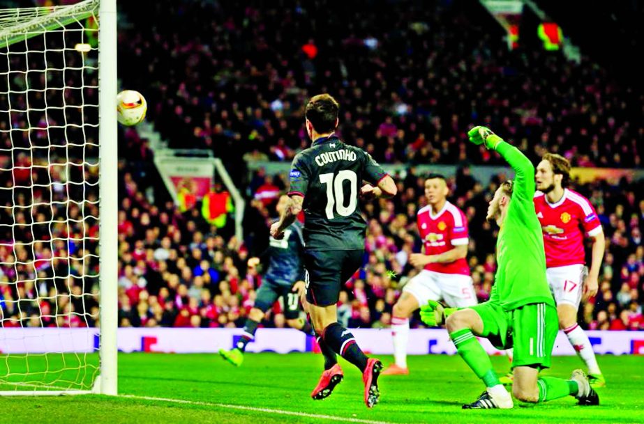 Liverpool's Philippe Coutinho (center) scores his side's first goal past United goalkeeper David De Gea during the Europa League round of 16, second leg, soccer match between Manchester United and Liverpool at Old Trafford Stadium in Manchester, England