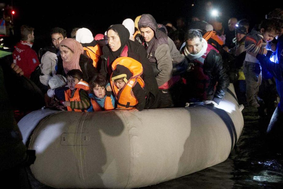 An overcrowded boat with dozens of migrants and refugees from nearby Turkey arrives at the shore of the northeastern Greek island of Lesbos, after crossing the Aegean sea from Turkey, on Sunday.