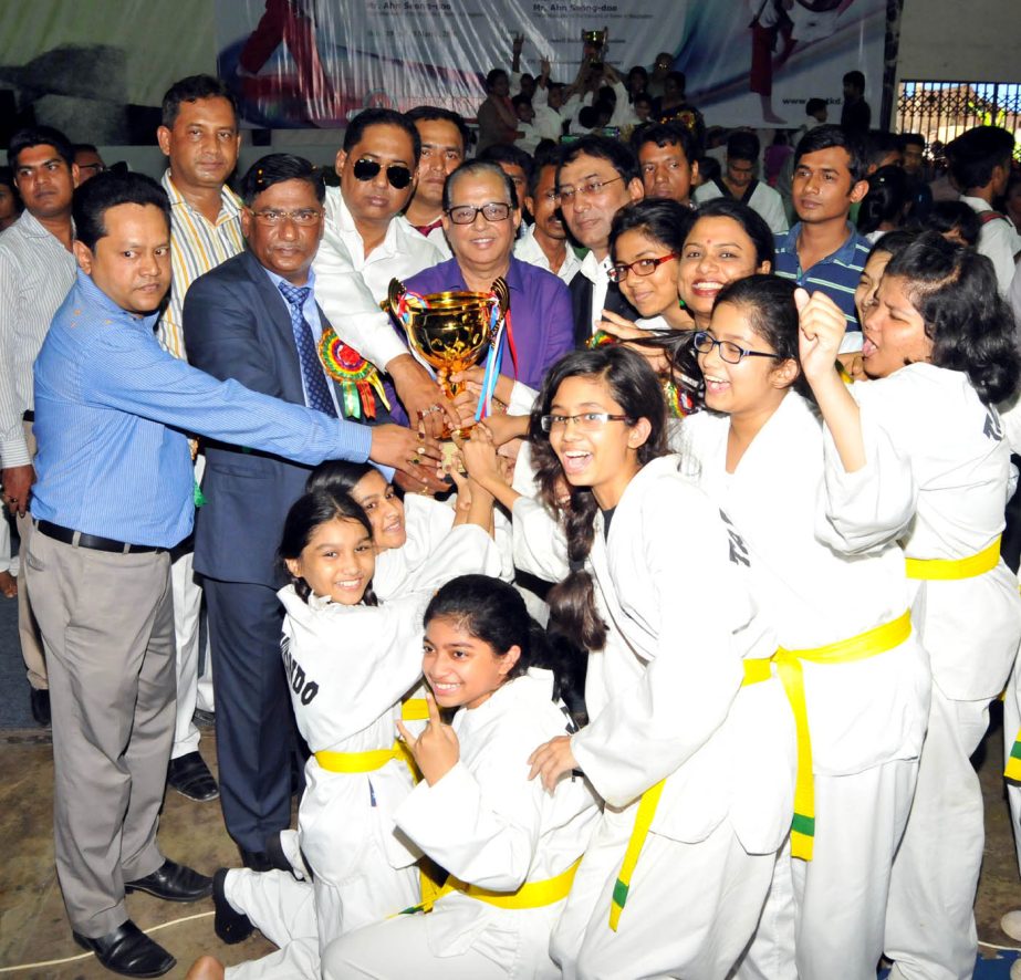 Bangladesh Jute Mills Corporation, who emerged champions in the men's senior division in Kukkiwon Cup Taekwondo pose for photo with State Minister for Youth and Sports Sri Biren Sikder, MP at the National Sports Council Gymnasium on Sunday.