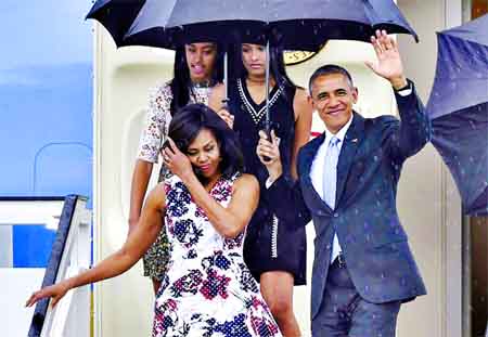 US President Barack Obama waves next to First Lady Michelle Obama (L) and their daughters Malia (L, behind) and Sasha upon their arrival at Jose Marti international airport in Havana.