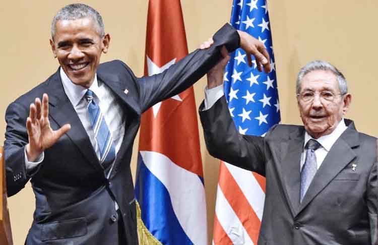 Cuban President Raul Castro raises US President Barack Obama's hand during a meeting at the Revolution Palace in Havana on Monday.