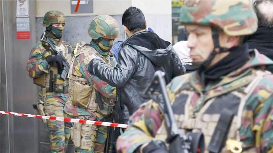 Belgian troops search people entering a subway station following Tuesday''s bomb attacks .