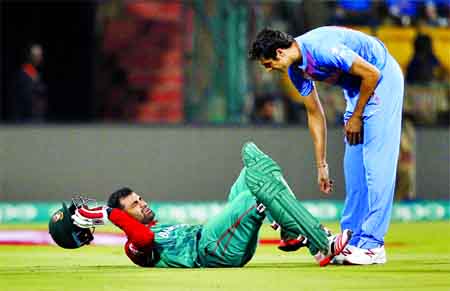 Bangladesh's cricketer Tamim Iqbal (left) reacts after a mid-pitch collision with India's Ashish Nehra, (right) during their ICC World Twenty20 2016 cricket match in Bangalore, India on Wednesday.