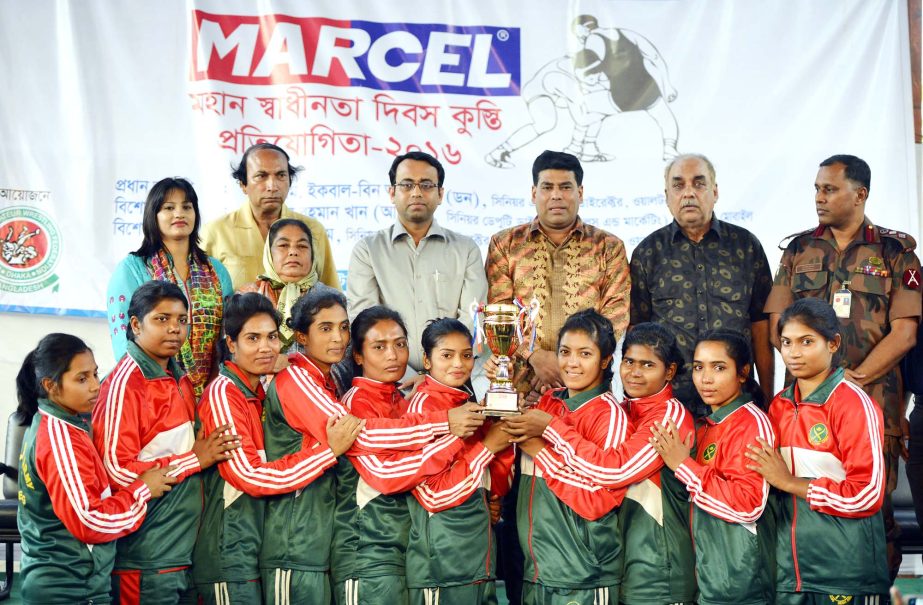 Bangladesh Army, the champions of the Women's Division of the Marcel Independence Day Wrestling Competition with the guests and officials of Bangladesh Amateur Wrestling Federation pose for a photo session at the Kabaddi Stadium on Thursday.