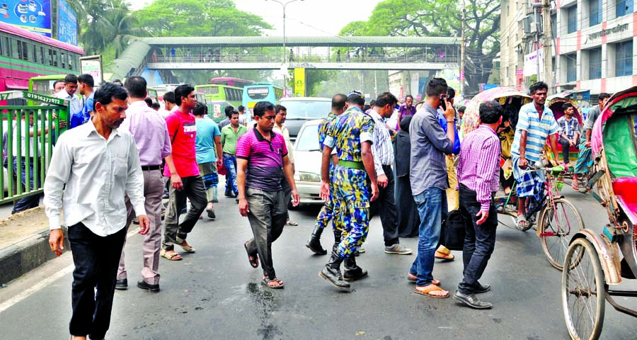 Pedestrians are crossing busy road defying traffic signal and also risking their lives, whereas a footover bridge is seen just a few yards away. It's a common scenario in the city and everyday affair. This photo was taken from Topkhana area in the city o