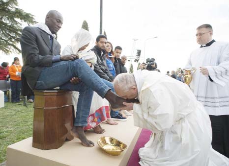Pope Francis kisses the foot of a man during the foot-washing ritual at the Castelnuovo di Porto refugees centre, some 30km (18, 6 miles) from Rome, on Thursday