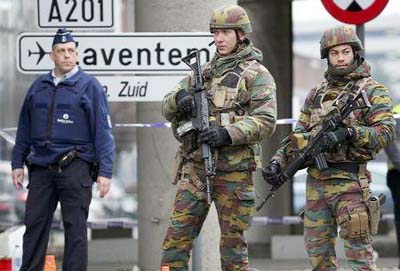 Masked Belgian police secure the entrance to a building in Schaerbeek during police operations following Tuesday's bomb attacks in Brussels, Belgium.