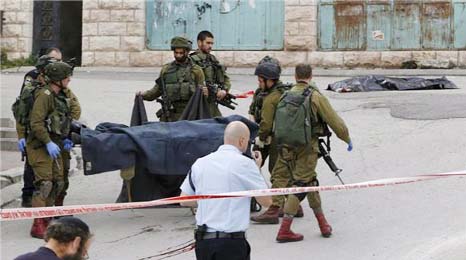 Photo shows Israeli soldiers carrying a Palestinian dead body.