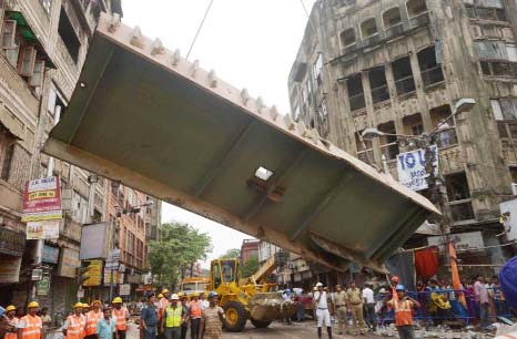 Rescue workers try to free people trapped under the wreckage of a collapsed flyover bridge in Kolkata on Friday.