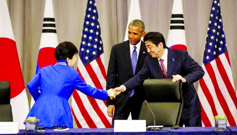 US President Barack Obama stands behind as South Korean President Park Geun-Hye (L) and Japanese Prime Minister Shinzo Abe shake hands at the end of their trilateral meeting at the Nuclear Security Summit in Washington on Thursday.