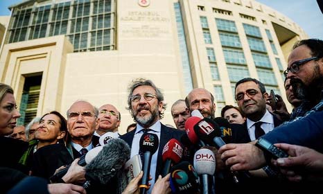 Turkish opposition Cumhuriyet Daily Editor in Chief Can Dundar (C) speaks to media and Ankar Bureau Chief Erden Gul (3rd) listens as they leave the Istanbul Court House on the 2nd day of their trial on Friday.