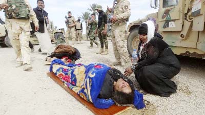 An injured woman comforts another as they wait for treatment after clashes between Iraqi Security forces and Islamic State extremists in a village outside Ramadi.