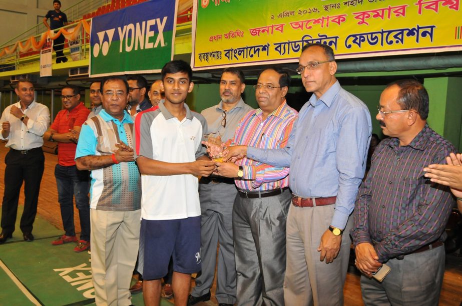 Secretary of the National Sports Council Ashok Kumar Biswas distributes the prize to a winner of the Gazi Group 34th National Badminton Championship at the Shaheed Tajuddin Ahmed Indoor Stadium in Paltan Maidan on Saturday.