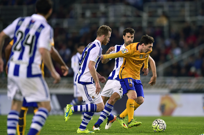 Barcelona's Lionel Messi of Argentina (right) duels for the ball with Real Sociedad's David Zurutuza (center) during their Spanish La Liga soccer match, at Anoeta stadium in San Sebastian, northern Spain on Saturday.