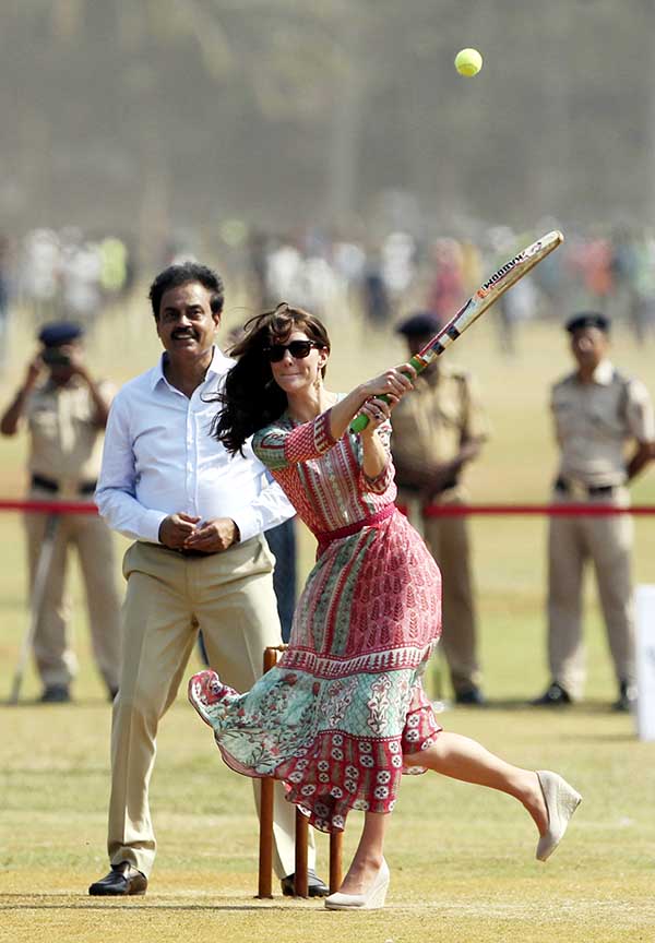 Britain's Kate, the Duchess of Cambridge, plays cricket as former Indian cricket captain Dilip Vengsarkar watches at Oval Maidan in Mumbai, India, Sunday. The Duke and Duchess of Cambridge paid their respects at one of the sites of the 2008 Mumbai terror