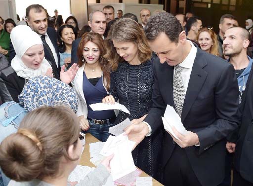 Syrian President Bashar al-Assad (R) and his wife Asma (C) cast their votes at a polling station in Damascus on Wednesday.