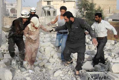 Syrian rescue workers and residents help an injured woman following a reported air strike by government forces on the rebel-held neighbourhood of Haydariya in Aleppo