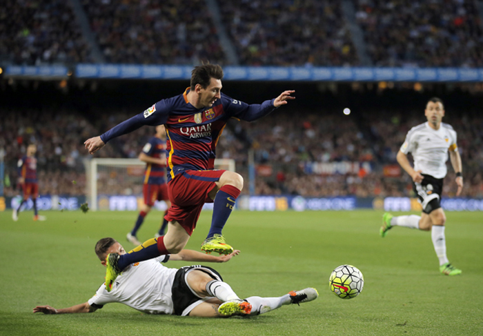 FC Barcelona's Lionel Messi (second left) duels for the ball against Valencia's Guilherme Siqueira during a Spanish La Liga soccer match between FC Barcelona and Valencia at the Camp Nou stadium in Barcelona, Spain on Sunday. FC Barcelona lost the match