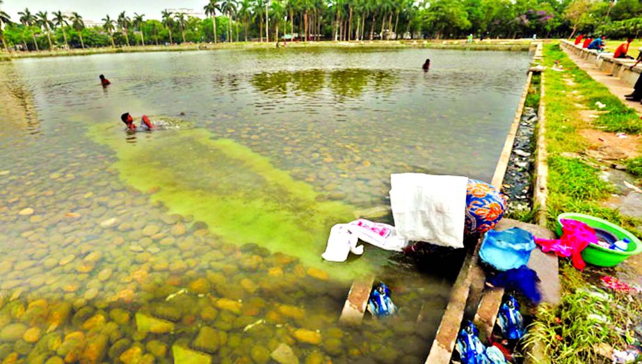 Floating people are polluting the water by taking bath and washing dirty clothes in the lake in the Suhrawardy Uddyan in the city. This picture was taken on Tuesday.