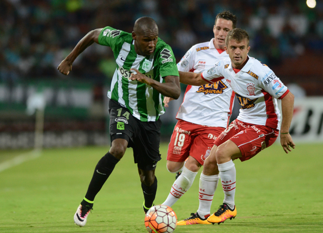 Victor Ibarbo of Colombia's Atletico Nacional, (left) battles for the ball with Mauro Bogado (center) and Luciano Balbi of Argetina's Huracan (right) during a Copa Libertadores soccer match in Medellin, Colombia on Tuesday.