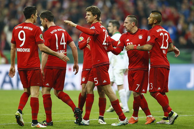 Bayern's Thomas Mueller (center) celebrates with teammates after scoring his side's second goal from the penalty spot during the German soccer cup (DFB Pokal) semi final match between FC Bayern Munich and SV Werder Bremen at the Allianz Arena stadium in