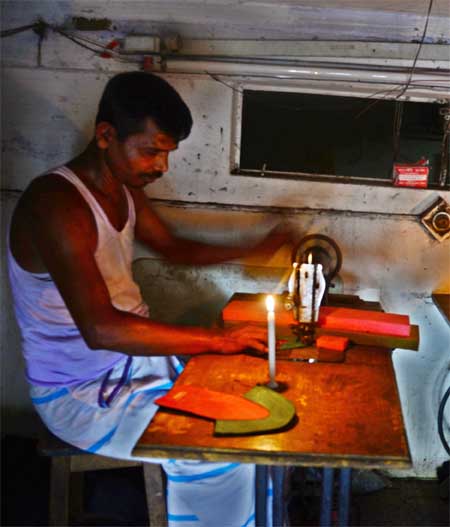 Due to frequent load-shedding workers at a tailoring house performing duties by using candlelight. This picture was taken in city's Abdul Hadi Lane area on Tuesday.