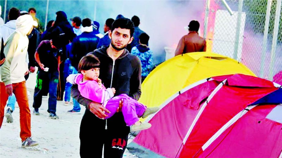 A man holds a child during rioting at the Moria detention centre on Tuesday.