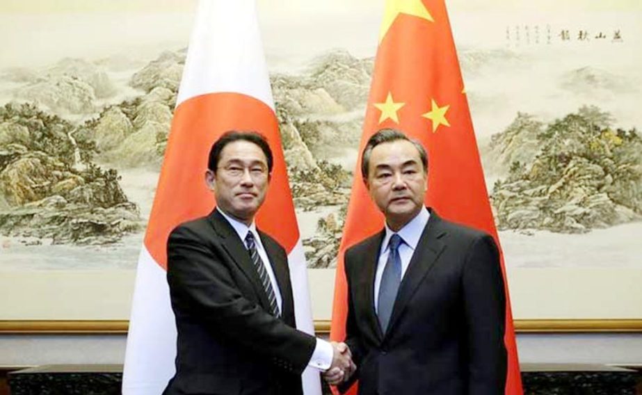 Japanese Foreign Minister Fumio Kishida (L) shaking hands with China's Foreign Minister Wang Yi during a meeting at Diaoyutai State Guesthouse, in Beijing, China, on Saturday.