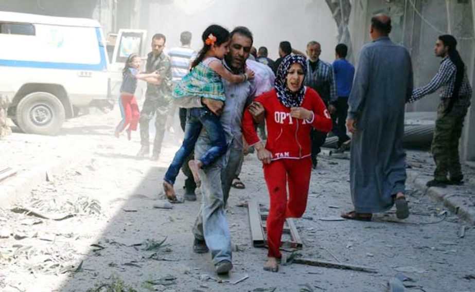 A Syrian family runs for cover amid the rubble of destroyed buildings following a reported air strike on the rebel-held neighbourhood of Al-Qatarji in the northern Syrian city of Aleppo on Friday.