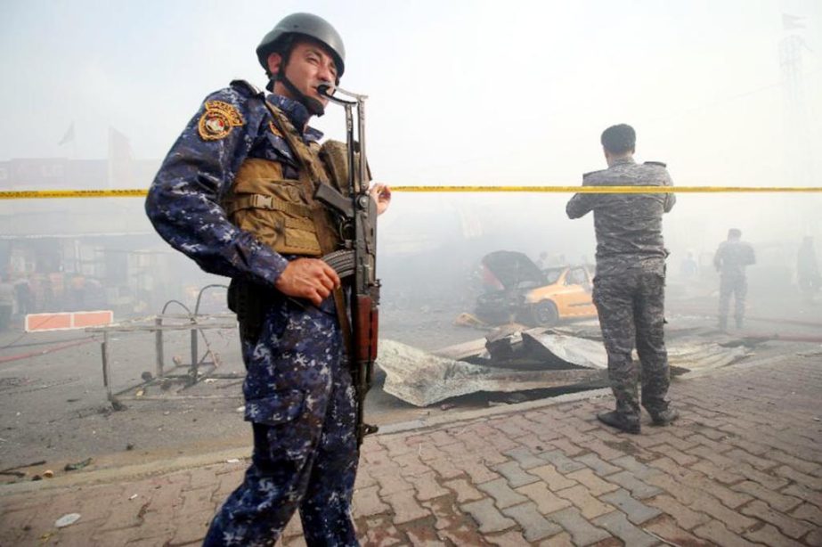 Iraqi security forces secure the site of a suicide bombing in the Baghdad Nahrawan area.