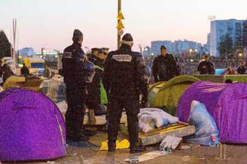 French police officers and gendarmes evacuate migrants from a makeshift camp under the Stalingrad metro station in Paris on Monday.