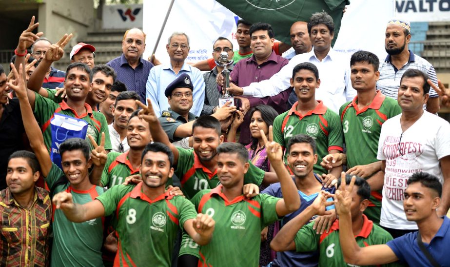 Players of Bangladesh Jail Volleyball team celebrate with the champions trophy of Division Volleyball League beating East & Club at the Volleyball Stadium on Monday.