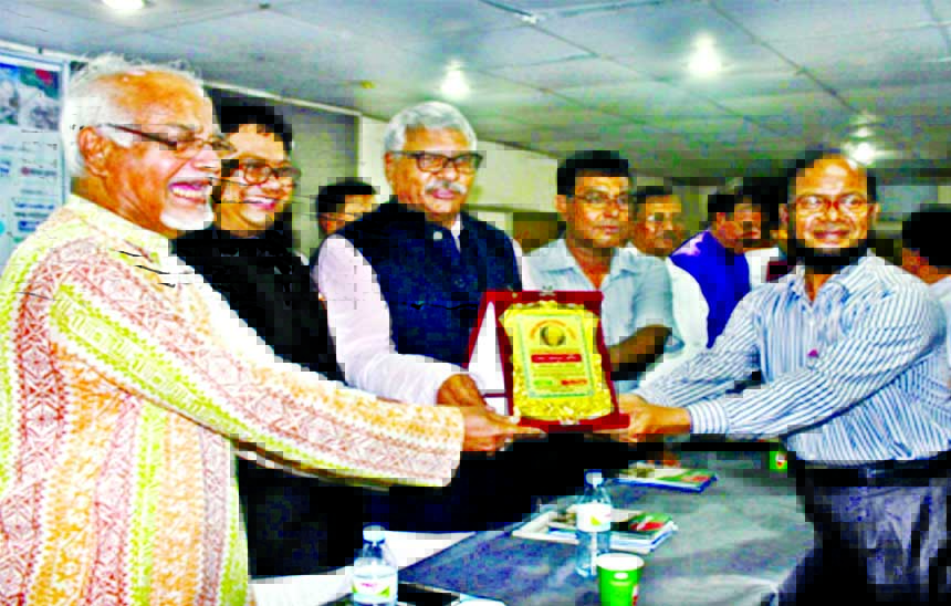 Former State Minister for Home Advocate Shamsul Haque Tuku handing over Mother Teresa citation to Abdul Rashid Sarker for his contribution in literature at a ceremony organized by Umar Prokashani in the auditorium of Bangladesh Shishu Kalyan Parishad in t