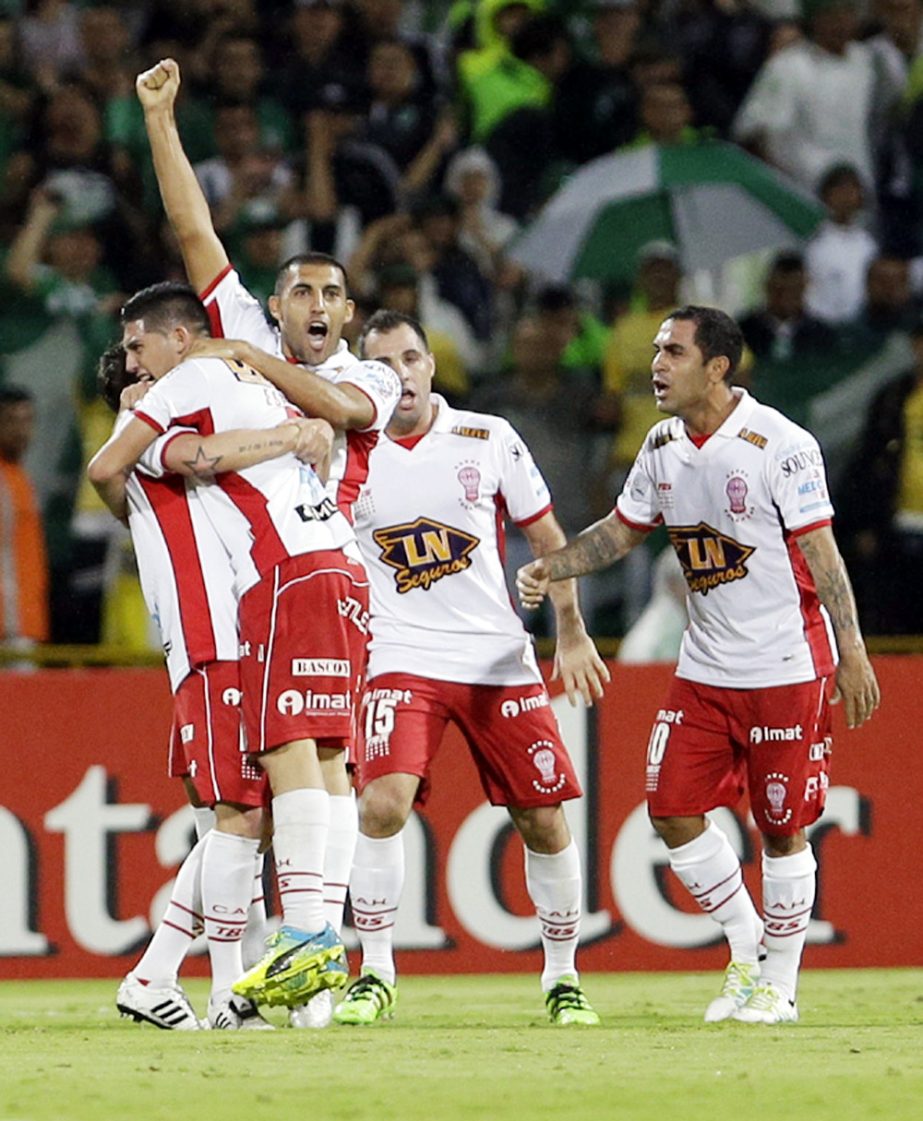 Cristian Espinosa of Argentina's Huracan (second from left) celebrates with teammates after scoring his side's first goal against Colombia's Atletico Nacional during a Copa Libertadores round of sixteen second leg soccer match in Medellin, Colombia on