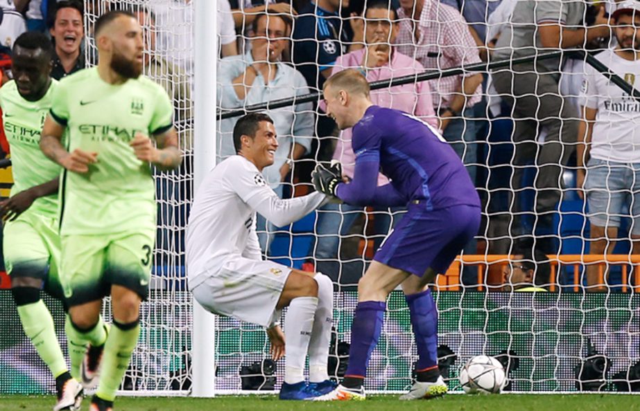 Manchester City goalkeeper Joe Hart (right) helps Real Madrid's Cristiano Ronaldo get back on his feet during the Champions League semifinal second leg soccer match between Real Madrid and Manchester City at the Santiago Bernabeu Stadium in Madrid on Wed