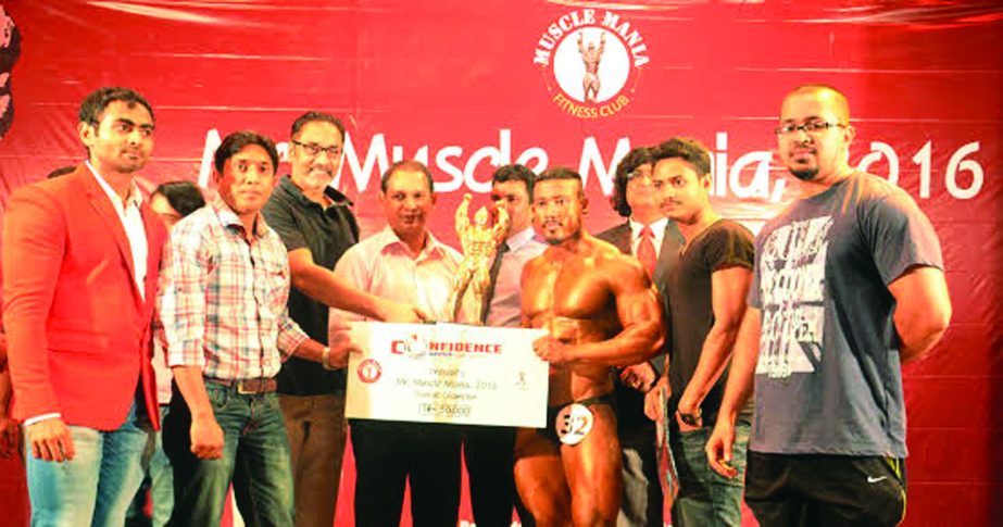 Sumon Das, the Mr Muscle Mania receiving the cheque of Tk 50,000 and a crest from the Director of the Confidence Group Md Salman Karim at the Auditorium of National Sports Council Tower on Friday.