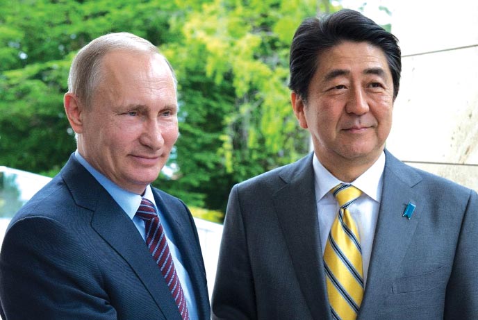 Russian President Vladimir Putin (L) welcomes Japanese Prime Minister Shinzo Abe in Sochi on Friday.