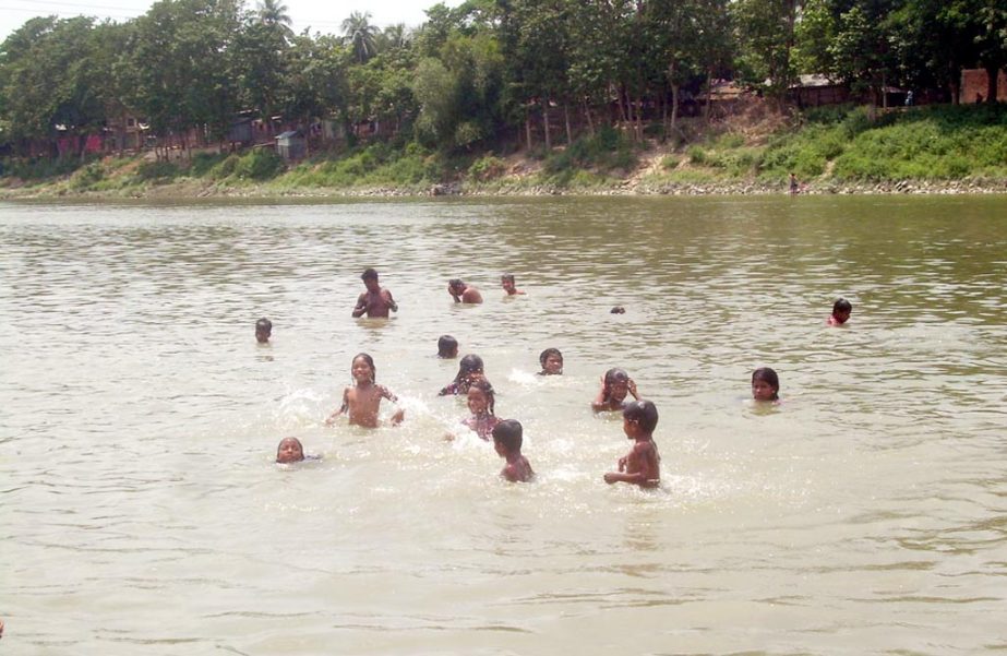 Children trying to get relieve from heat weave by swimming in Chandonaish Shankho River. This picture was taken from Dohazari area on Friday.