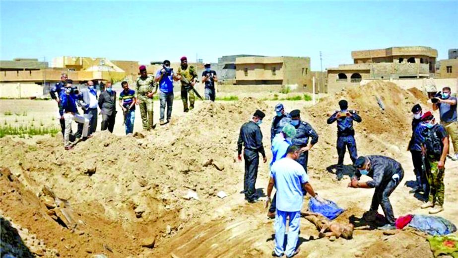 Iraqi security forces including a forensics team work at the site of a mass grave found in the stadium area in Ramadi.