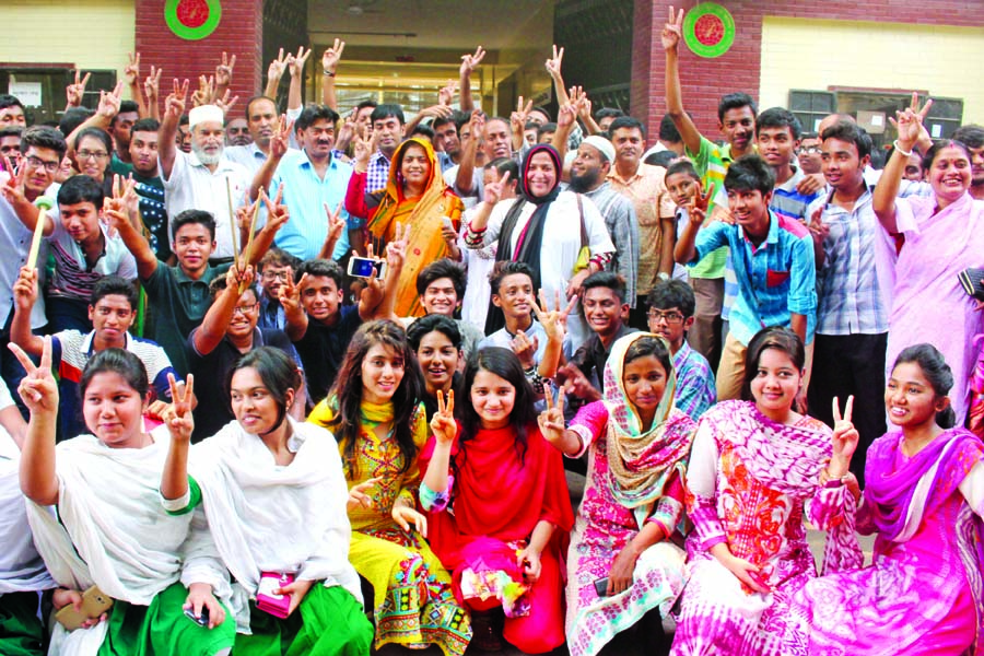 Teachers and students of the city's Motijheel Ideal School and College flashing Victory (V) sign as the institution makes good result in the SSC examination this year. The snap was taken from the school premises on Wednesday.